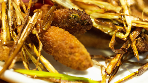 Pan tostado con espárragos trigueros empanados envueltos en jamón y puerro laminado